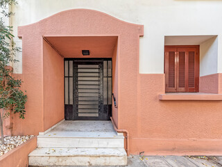 Fototapeta na wymiar classic design colorful house front and entrance metallic door and wooden window by the sidewalk