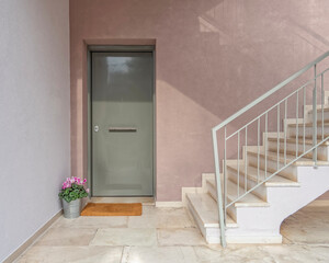 classic design house front entrance metallic grey door with potted cyclamen flower