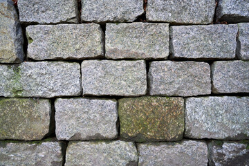 Old wall made of gray granite stones. Fullframe. Pattern
