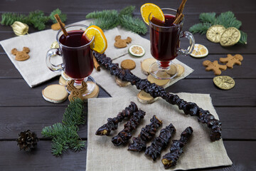 Churchela, mugs of warm wine with an orange, and cookies, ingredients on a wooden brown table....