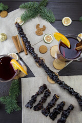 Churchela, mugs of warm wine with an orange, and cookies, ingredients on a wooden brown table....