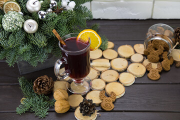 Mugs of warm wine with orange, cookies and cinnamon, dried fruit and spruce branches, Mulled wine,...