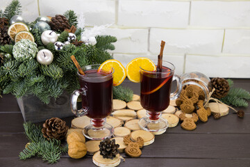Mugs of warm wine with orange, cookies and cinnamon, dried fruit and spruce branches, Mulled wine