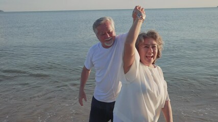 Asian couple senior elder retire resting relax dancing at sunset beach