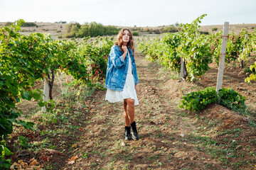 beautiful woman in white dress and denim jacket in the vineyards