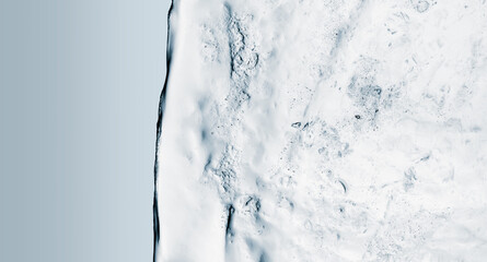 Fragment of pure transparent rectangular ice block on light gray background.