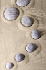 Fototapeta na wymiar Round stones on smooth sand in the rock garden, for relaxation and spiritual harmony.