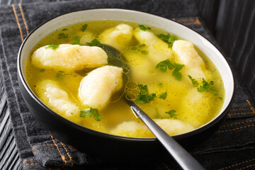 Recipe for Soup with Semolina Dumplings close-up in a plate on the table. horizontal