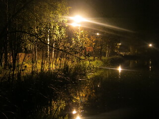pond on an autumn night in the light of lanterns