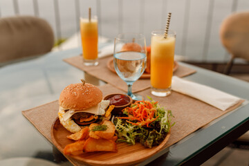 Gourmet Burger with potatoes and  salad  on wooden plate