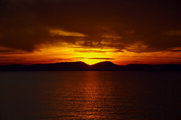 Sky on fire during sunrise or sunset twilight over the Mediterranean Sea with mountain coast...