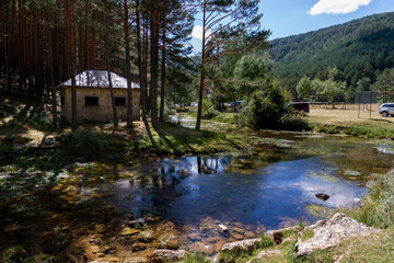 Source of the arlanza river with refuge and reflection in the river next to Quintanar de la Sierra in Burgos, Spain