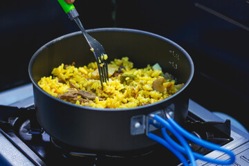 Cooking paella in camping gas in the mountains