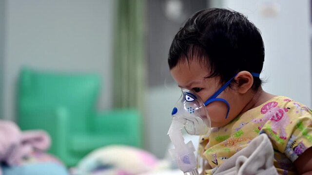 Asian baby was sick as Respiratory Syncytial Virus (RSV) in kid hospital. Thai little girl having inhaler containing medicine for stop coughing and disease flu.