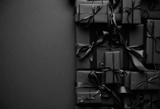 A pile various size black boxed gifts placed on stack. Christmas concept.