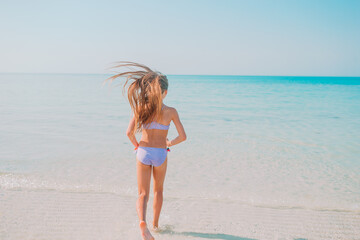Naklejka premium Adorable active little girl at beach during summer vacation