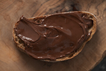 Ciabatta slices with chocolate spread on olive wood board