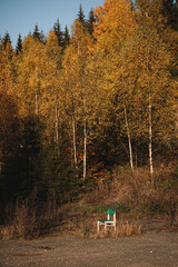 Single white wooden chair outdoors on gravel