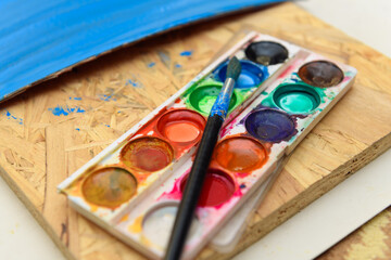 watercolor paints and paper closeup for drawing, artistic creation at home, workspace for make creative artwork