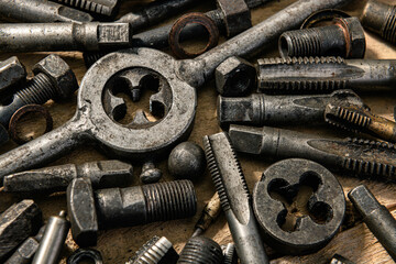 Old vintage drills and threading die tools on a wooden background