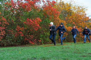 Fototapeta premium family running in autumn city park, happy people together, parents and children, beautiful nature with colorful leaves