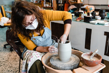 Charming pottery master making ceramic pottery on wheel. Handcraft.