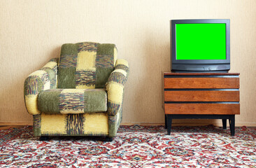 Antique TV with green screen on an antique wooden cabinet, old design in a house in the style of...