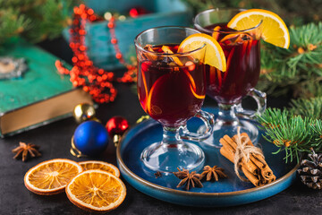 Hot Christmas drink made of wine, fragrant spices and fruits in a glass on a wooden rustic...