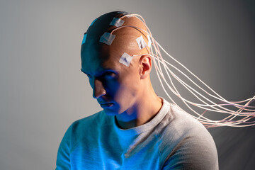 man with electrodes in his head is a futuristic concept of virtual reality and mind control.