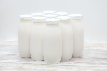 Natural liquid yogurt with probiotics in small plastic bottles on wooden table. Healthy, balanced diet food, healthy breakfast, dairy products. Selective soft focus, blurred background