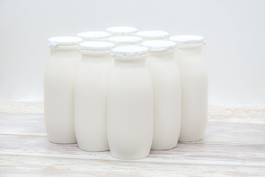 Natural liquid yogurt with probiotics in small plastic bottles on wooden table. Healthy, balanced diet food, healthy breakfast, dairy products. Selective soft focus, blurred background