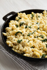 Homemade Spinach Mac and Cheese in a cast-iron pan, side view. Close-up.