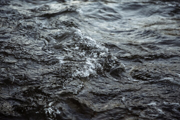 Fast river water with waves, foam and splashes. 