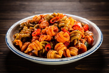 Pasta with tomato sauce, meat and parmesan on wooden table