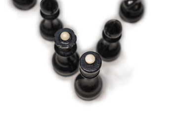 Wooden chess pieces. Black king and Queen surrounded by their large retinue, standing behind each other, top view