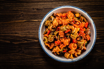 Pasta with tomato sauce, meat and parmesan on wooden table