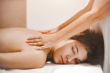 Obraz na płótnie Canvas Masseur hands doing spin shoulder massage.