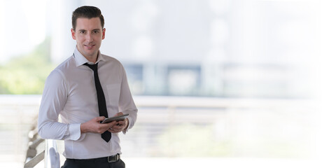 Portrait of smiling businessman using at tablet