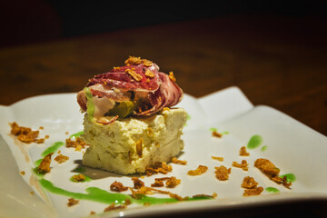 Detail of bar food skewer on wooden table with ham
