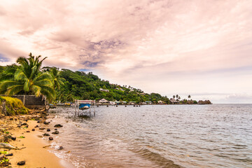 sunset on the beach with boat in tropical island 