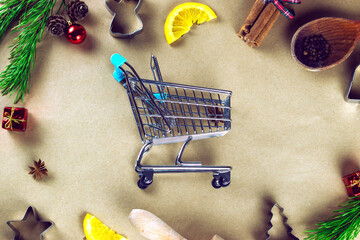 Shopping cart among Christmas decorations, , dried oranges and Christmas tree branches.