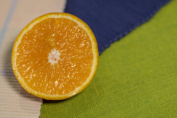A sliced orange on a green and blue cloth.