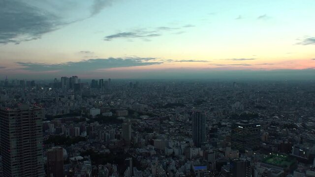 TOKYO, JAPAN : Aerial high angle sunrise CITYSCAPE of TOKYO. View of buildings around Shinjuku and Nakano ward. Japanese urban metropolis concept shot. Time lapse tracking shot night to morning.