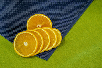 Sliced orange slices on a green and blue cloth.