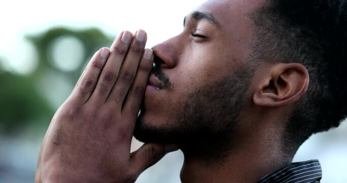 Spiritual young black African man praying to GOD. Person looking to sky with HOPE and FAITH