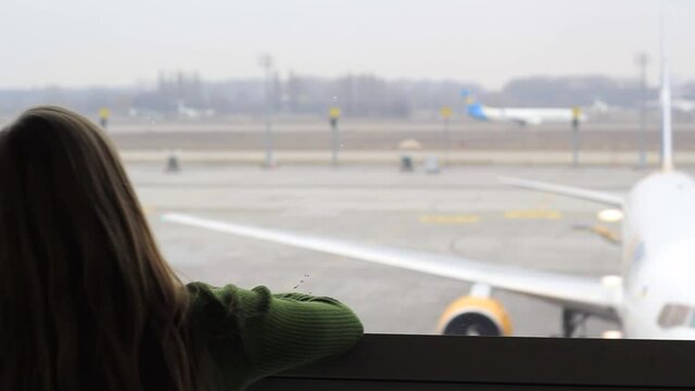 The Girl In The Waiting Room Watches The Plane Take Off.