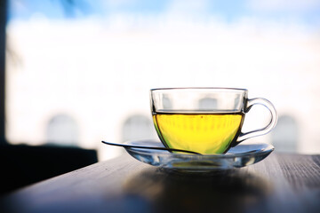 Hot steaming green tea in a cup on a rustic background
