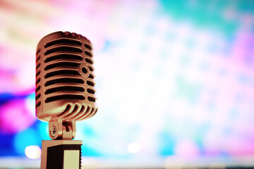Fototapeta na wymiar Retro style microphone on background backlight. Vintage Microphone for sound, music, karaoke. Speech broadcast equipment. Live pop, rock musical performance. Selective focus