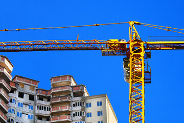 Construcrion site background. Concrete building under construction. Big tower crane. Industrial background.