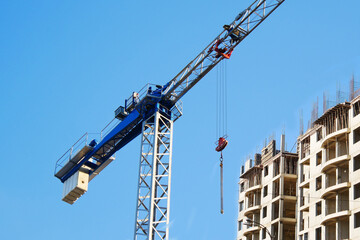 Construcrion site background. Concrete building under construction. Big tower crane. Industrial background.